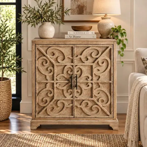 Closed two-door wooden storage cabinet with symmetrical scrollwork, dark vertical handles and a natural distressed finish styled in a warm living room.