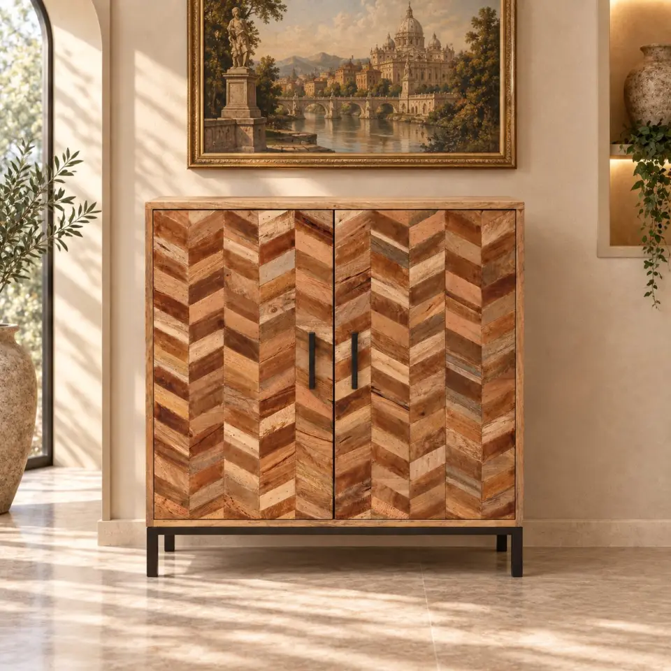 Two door mango wood storage cabinet with chevron-patterned door fronts, black vertical handles and a dark metal base displayed in a warm sunlit interior.
